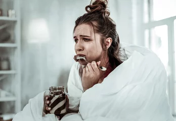 Muurstickers Woman eating chocolate pasta because of being stressed © Viacheslav Yakobchuk