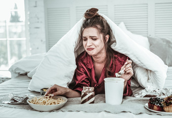 Depressed woman seizing stress with lots of sweet
