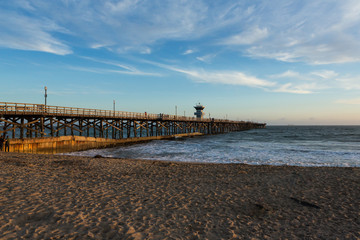 Fototapeta na wymiar Sunset over an ocean pier on the west coast