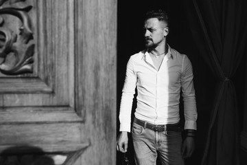 Young man wearing white shirt on street. Dramatic sun light. Fashion concept. Religion and emotion of theater