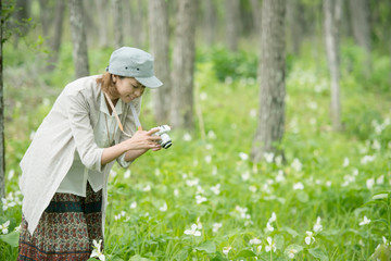 ミラーレス一眼カメラで植物の写真を撮る女性