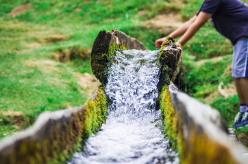 clear spring water descends towards the valley with a young boy