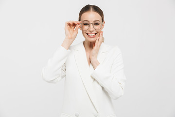 Photo of successful businesswoman 20s wearing elegant jacket smiling at camera and holding eyeglasses