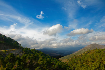 Green mountains and blue sky with clouds, view from the top, spring