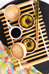 Asian Food concept homemade Dim Sum fried steamed garlic chives dumplings in Dim Sum Bamboo Steamer Basket on black matt background
