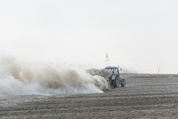 Tractor fertilizes agricultural fields