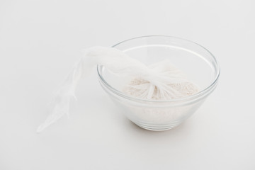 rice in cheesecloth in glass bowl on grey background