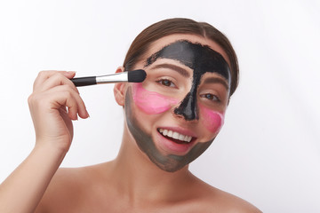 Excited woman opening her mouth while using facial masks