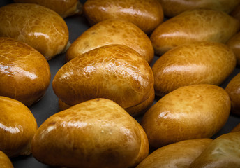 Ready homemade triangular stuffed buns on baking tray 