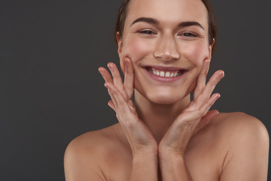 Cute Young Woman Pulling Up The Corners Of Her Mouth With Fingers