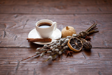 Coffee cup and willow branches, dry lemon, cinnamon.