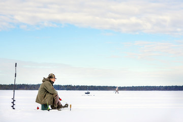 man catches a fish in the winter