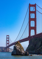 The Golden Gate Bridge is photographed from below in sunny weather.