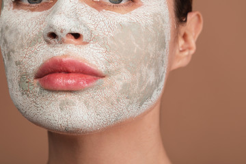 Calm woman treating her skin with clay facial mask