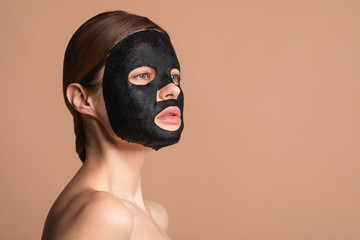 Woman with black mask on the face thoughtfully looking away