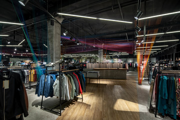 Modern clothes shop with large selection of different wear and shoes