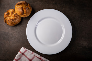 Table setting. White plate and meal ingredients on the table.