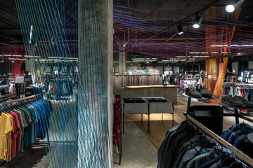 Modern clothes shop with large selection of different wear and shoes