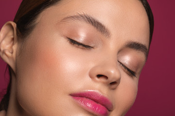 Woman with pink lips closing her eyes and smiling