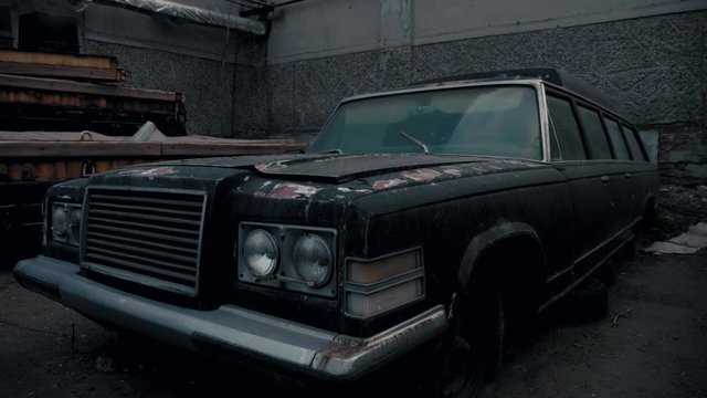 Old black abandoned rusty coffin. Legendary car.