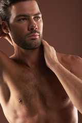 Fototapeta premium Young handsome topless male model posing on camera