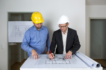 Der Architekt skizziert die wichtigen Bereiche für den Bauherren in den Bauplan