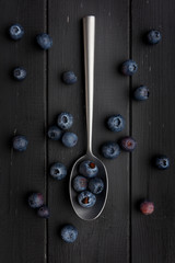 blueberries and silver spoon on dark grey
