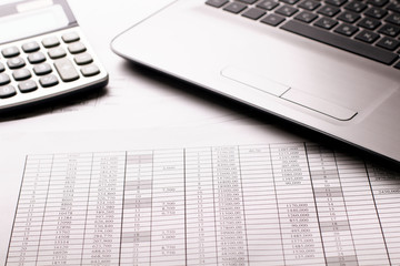 Accountant work table with calculator, charts and pen.