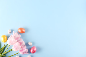 Bunch of hand painted Easter eggs of different pastel glossy color on bright paper background with a lot of copy space for text. Top view, flat lay, close up. Easter greeting card concept.