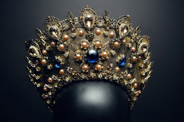 Head of mannequin in decorated bronze kokoshnick, dark studio background