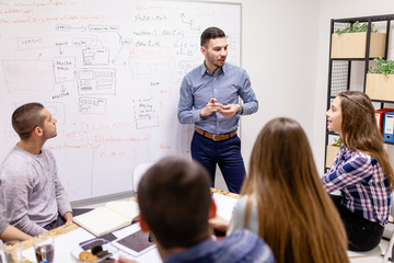 Obraz premium young creatives having a meeting. man in front of a whiteboard