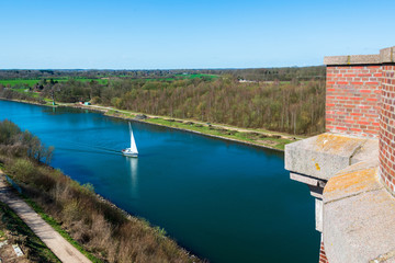 Blick von der Levensauer Hochbrücke über den Nord-Ostsee-Kanal. Eine Segelyacht passiert den Kanal in Richtung Holtenau.