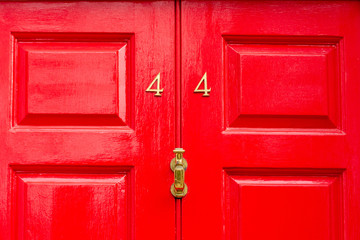 Shiny bright  red house number 44 with the forty four in bronze