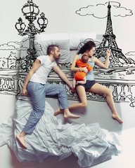 Paris is calling. Top view photo of young couple and their child sleeping in a big white bed....