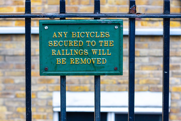 Metal sign stating: Any bicycles secured to the railings will be removed