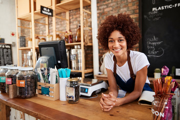 Portrait Of Female Owner Of Sustainable Plastic Free Grocery Store Behind Sales Desk