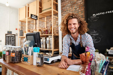 Portrait Of Male Owner Of Sustainable Plastic Free Grocery Store Behind Sales Desk