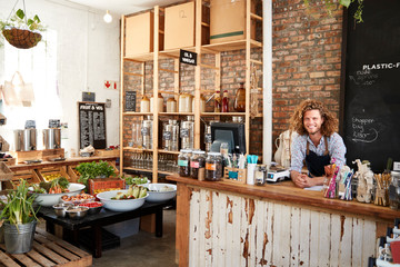 Portrait Of Male Owner Of Sustainable Plastic Free Grocery Store Behind Sales Desk