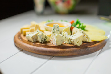 Delicious cheese on the table with honey and vegetables