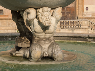 Fototapeta na wymiar Atlantean at the Fountain of Shame at the Pretoria square in Palermo - Sicily, Italy. Mythological figures such as the gods on Mount Olympus are carved in white marble.