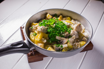 Fried potatoes with chicken, mushroom sauce and onion