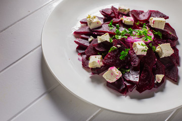 Vitamin salad with beets and Feta cheese in a white plate