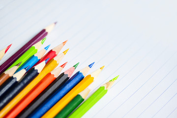 Obraz premium Colored pencil set on white paper notebook back to school and education concept / Crayons colorful