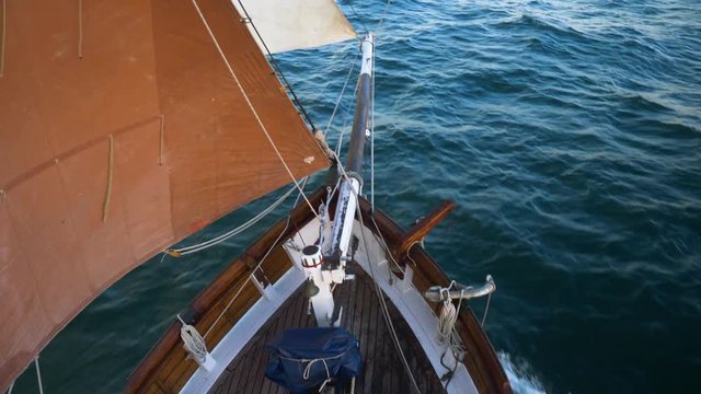 Sail full close hauled and bowsprit in view from above on a sailing boat in the open sea