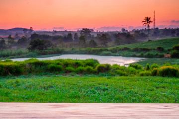 Empty wooden table with view of mountain or wooden desk with green grass nature with bokeh background, copy space for your text.