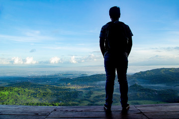 beautiful landscape view from Becici Pine Peak on yogyakarta, lonely man stand up in wooden floor...