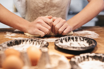 Close up of a woman wearing apron preparing dough