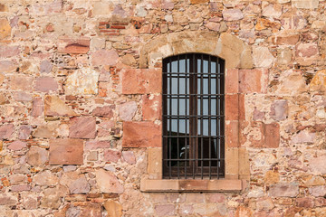 A window on the stone facade of the Montjuic Castle front view, Barcelona, Spain