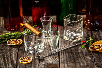 Selection of strong alcoholic drinks, glasses and shot glass in assortent: vodka, rum, cognac, tequila, brandy and whiskey. Dark vintage background, selective focus, copy space