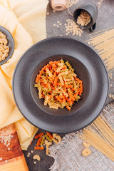 Different types of pasta on a black plate top view.